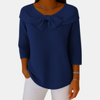 Front view of the Colette Bow-Tie Long Sleeve T-shirt in dark blue, featuring a bow neckline, ribbed knit texture, three-quarter sleeves, and a relaxed curved hem. Designed by Bella Hudson.