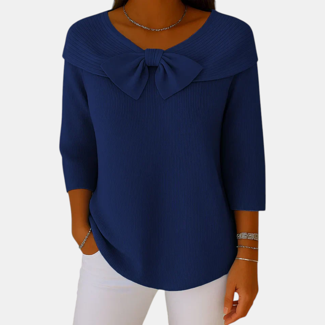 Front view of the Colette Bow-Tie Long Sleeve T-shirt in dark blue, featuring a bow neckline, ribbed knit texture, three-quarter sleeves, and a relaxed curved hem. Designed by Bella Hudson.