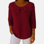 Front view of the Colette Bow-Tie Long Sleeve T-shirt in red, featuring a decorative bow neckline, ribbed fabric, three-quarter sleeves, and a flattering relaxed silhouette. Designed by Bella Hudson.
