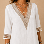 Close-up view of the Cora Midi Dress Lightweight Linen V-Neck Summer in white, featuring the intricate crochet-trimmed V-neckline, textured linen fabric, and premium craftsmanship. Designed by Bella Hudson.