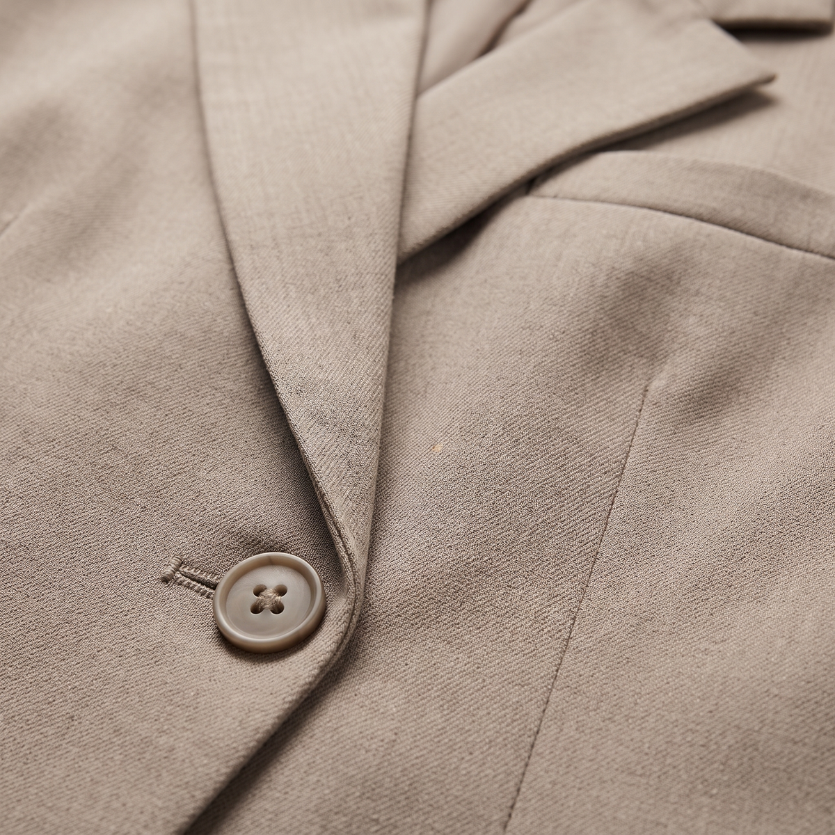 Coralie Taupe double-breasted blazer close-up of the peak lapel, button, and fabric texture.