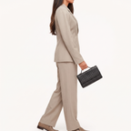 Coralie Taupe double-breasted blazer in a side view with matching pants and a black woven handbag.