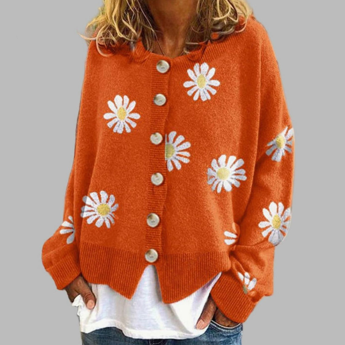 Daisy Orange button-front cardigan with an all-over daisy floral pattern, round neckline, long sleeves, ribbed trim, and relaxed fit