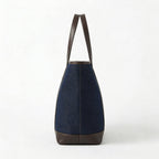 Side profile of dark blue denim tote bag with leather handles BELLA HUDSON