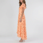 Side view of the Delphine Summer Maxi Dress Floral Print Flutter Sleeve in orange, showcasing the flutter sleeves, V-neckline, floral print, and graceful maxi-length silhouette. Designed by Bella Hudson.