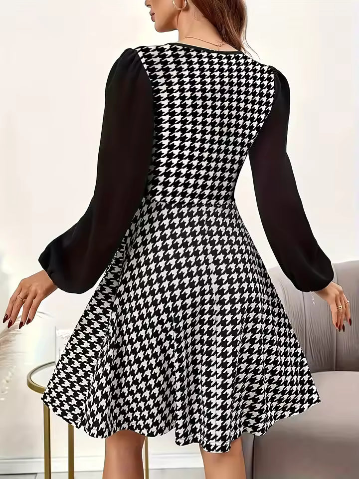 Diana Black houndstooth mini dress shown from the back, featuring long puff sleeves, fitted waist, and flared hem