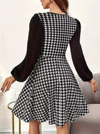 Diana Black houndstooth mini dress shown from the back, featuring long puff sleeves, fitted waist, and flared hem