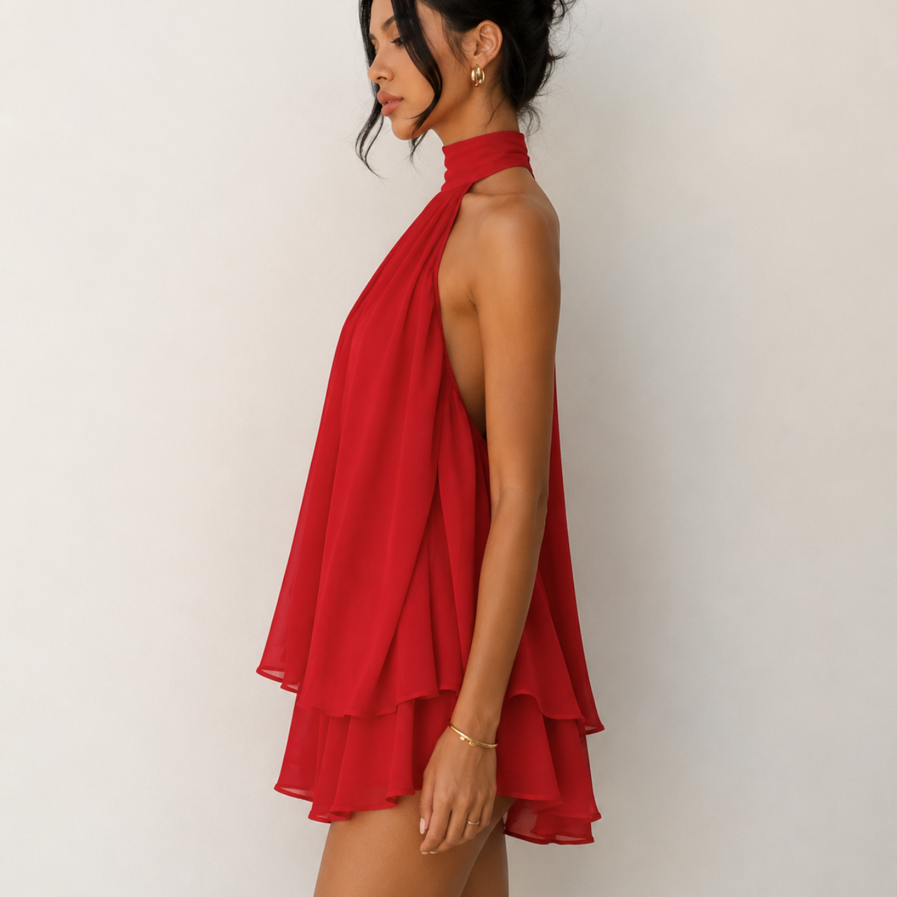 Side view of Diana Chiffon Halter Mini Dress in Red featuring a high halter neckline and layered flowy silhouette, designed by BELLA HUDSON