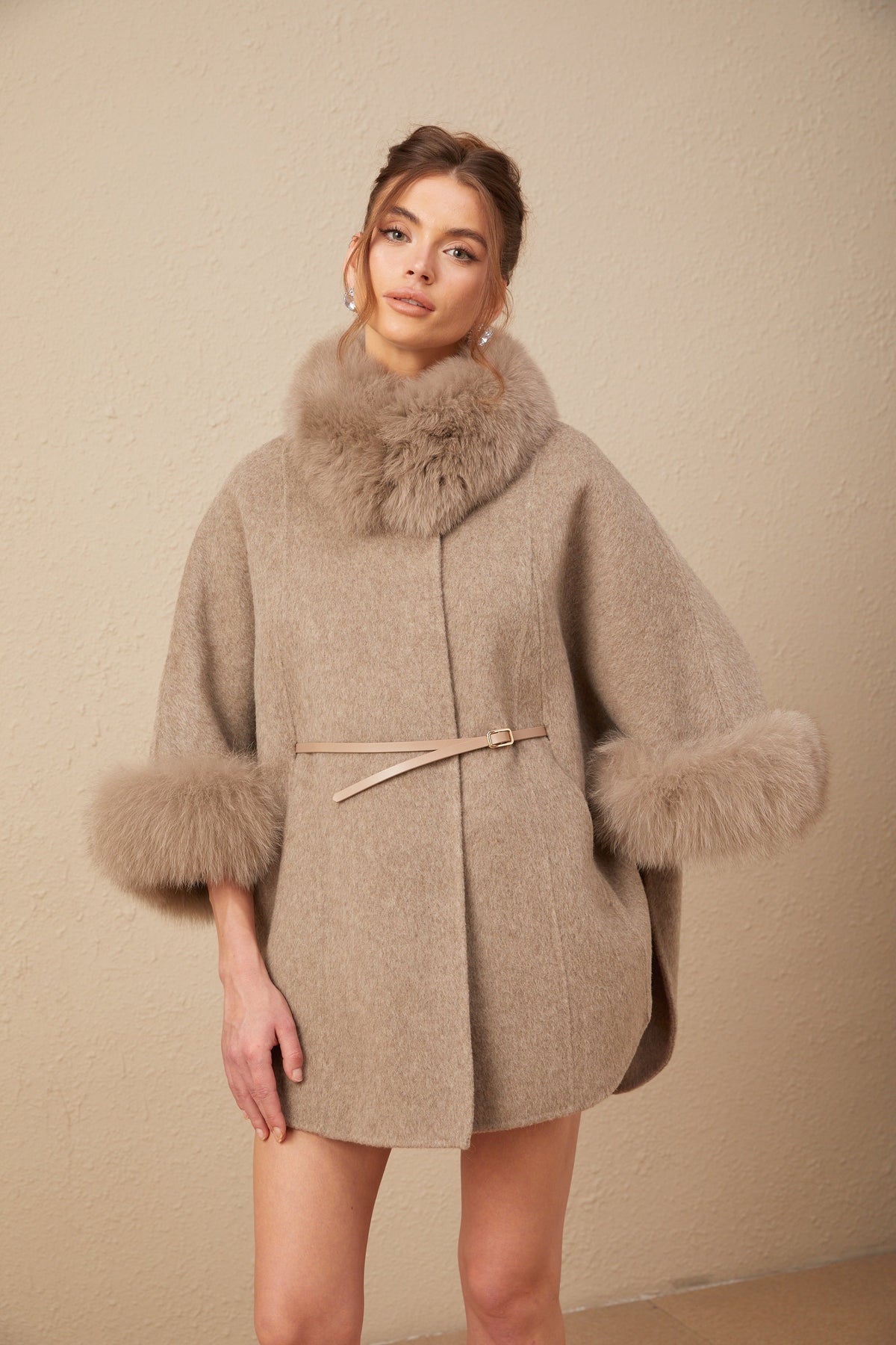 Elara Brown faux-fur trim cape coat shown full length with a relaxed cape silhouette, faux-fur cuffs, and waist belt
