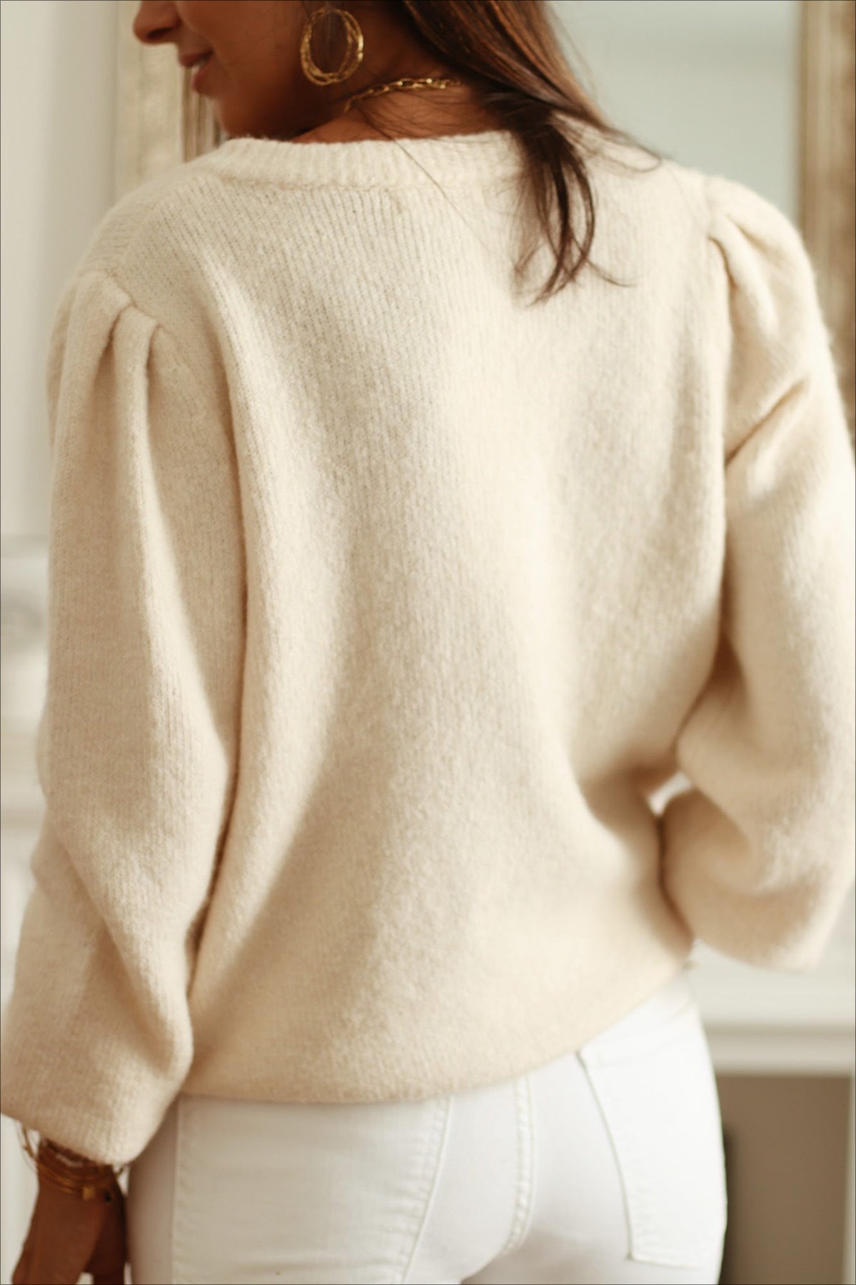 Elara White cardigan back view showing the puffed shoulders and relaxed long sleeves.