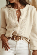 Elara White openwork knit cardigan with crew neck and button front, styled with white jeans and a brown belt.