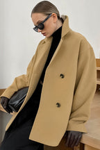 Elena Beige double-breasted boxy jacket shown from the side with notched lapels and a relaxed silhouette