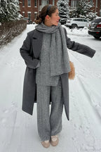 Elena Gray cable-knit sweater, wide-leg pants, and scarf styled with a long charcoal coat.