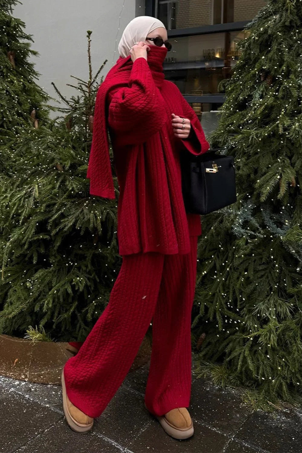 Elena Red cable-knit turtleneck sweater with wide-leg pants and a matching scarf worn as a wrap.