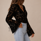 Side view of Elia Floral Lace Long Sleeve Blouse in Black showcasing the floral lace fabric and flowing long sleeve silhouette designed by Bella Hudson.
