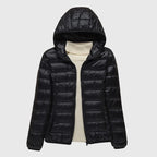 Elise Black lightweight puffer jacket featuring a quilted exterior, attached hood, full front zipper, and long sleeves
