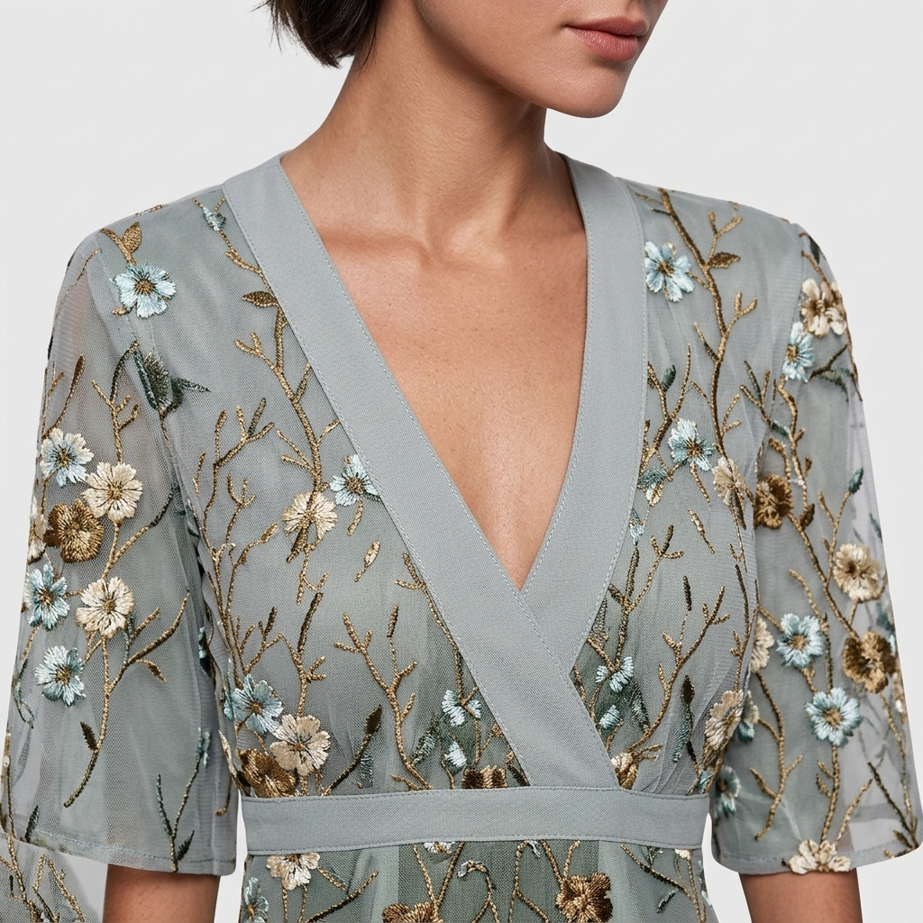 Close-up detail of the Elodie Summer Maxi Dress Floral Print Wide Sleeve in green, featuring the V-neck wrap neckline, wide flutter sleeves, floral print, and gathered waist detail. Designed by Bella Hudson.