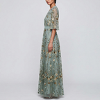 Side view of the Elodie Summer Maxi Dress Floral Print Wide Sleeve in green, showcasing the wrap-style bodice, wide flutter sleeves, floral print, and elegant flowing maxi silhouette. Designed by Bella Hudson.
