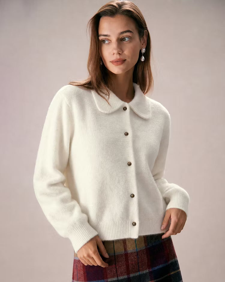 Elowen Apricot button-front cardigan styled with a plaid skirt, shown in a three-quarter view with the rounded collar visible.