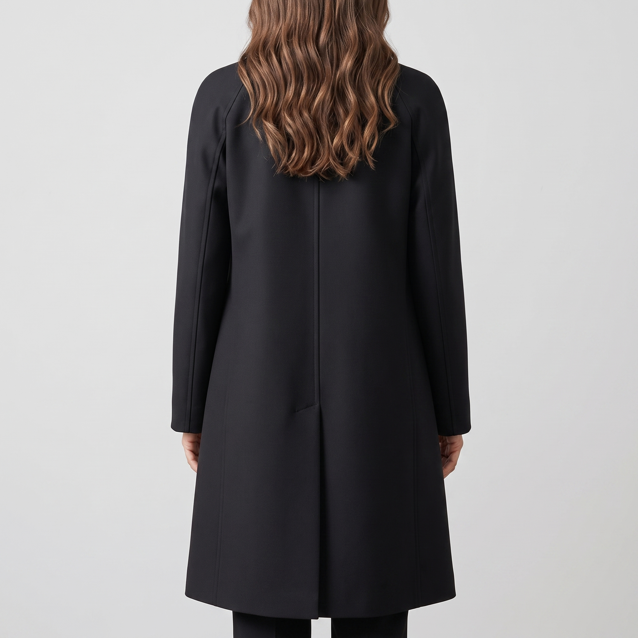 Back view of the Emilia Trench Coat Midi Double-Breasted in black, featuring a clean structured back, long sleeves, and a straight midi-length silhouette. Designed by Bella Hudson.
