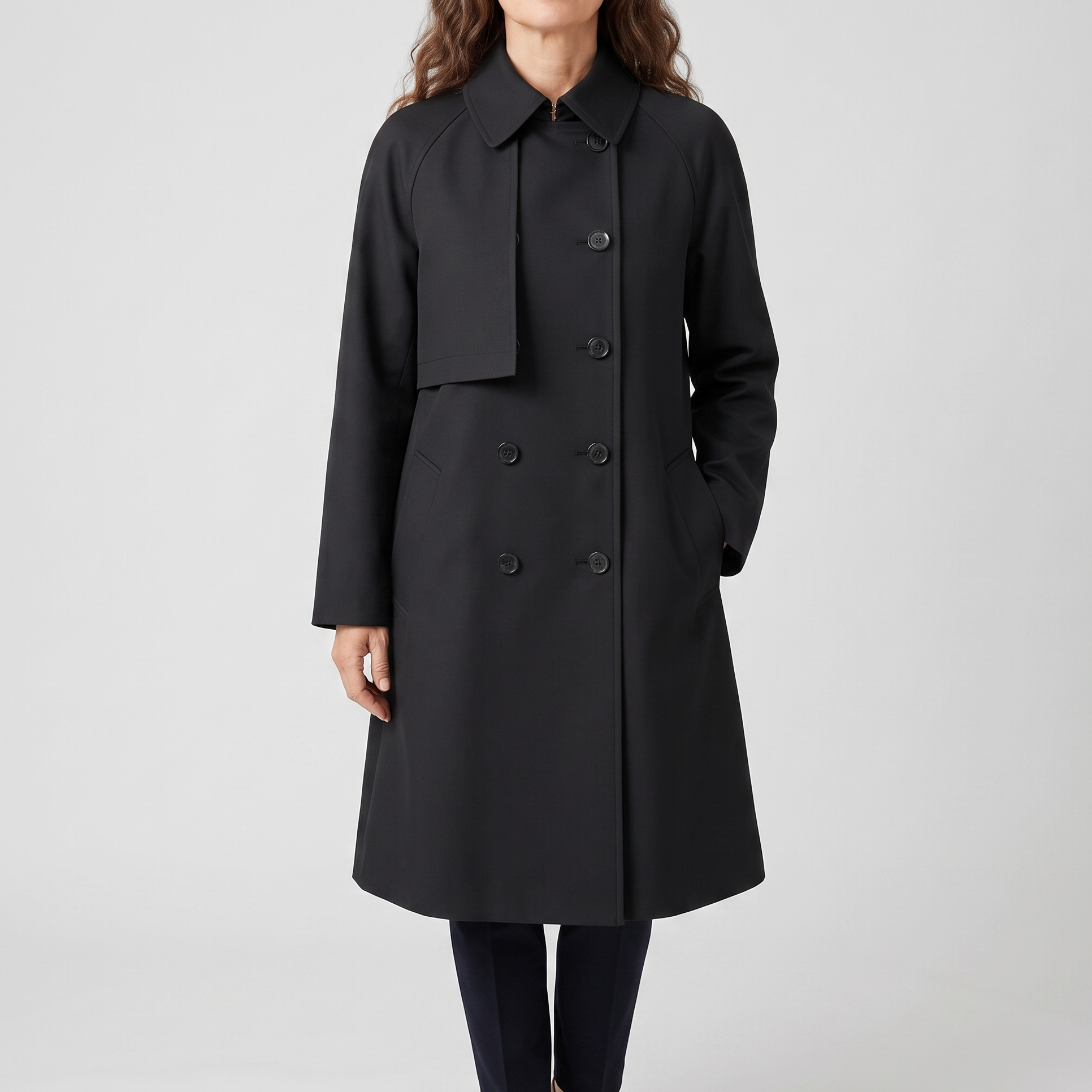 Front view of the Emilia Trench Coat Midi Double-Breasted in black, featuring a pointed collar, double-breasted buttons, long sleeves, side pockets, and a structured midi-length silhouette. Designed by Bella Hudson.
