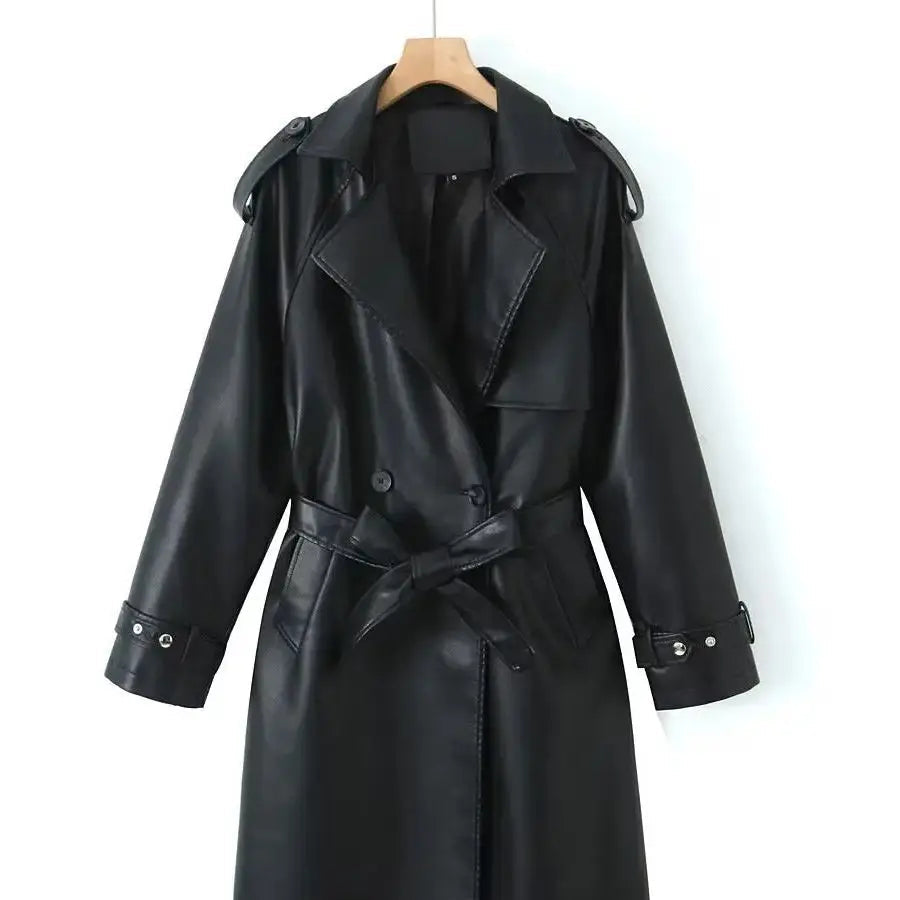 Front product view of the Emma Trench Coat Faux-Leather Belted in black, featuring wide notched lapels, a double-breasted button front, matching tie waist belt, long sleeves with cuff straps, and a knee-length faux-leather silhouette. Designed by Bella Hudson.
