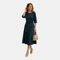 Front view of the Estelle Midi Dress Cotton A-Line Tie-Waist in green, featuring a round neckline, three-quarter sleeves, self-tie waist belt, and a flowing A-line silhouette. Designed by Bella Hudson.