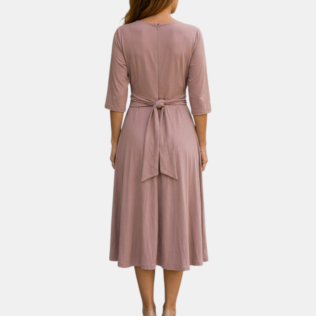 Back view of the Estelle Midi Dress Cotton A-Line Tie-Waist in pink, highlighting the gathered waist, three-quarter sleeves, and elegant midi-length silhouette. Designed by Bella Hudson.