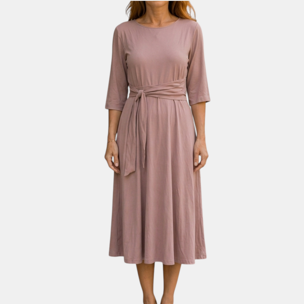 Front view of the Estelle Midi Dress Cotton A-Line Tie-Waist in pink, featuring a round neckline, three-quarter sleeves, self-tie waist belt, and a flowing A-line midi silhouette. Designed by Bella Hudson.