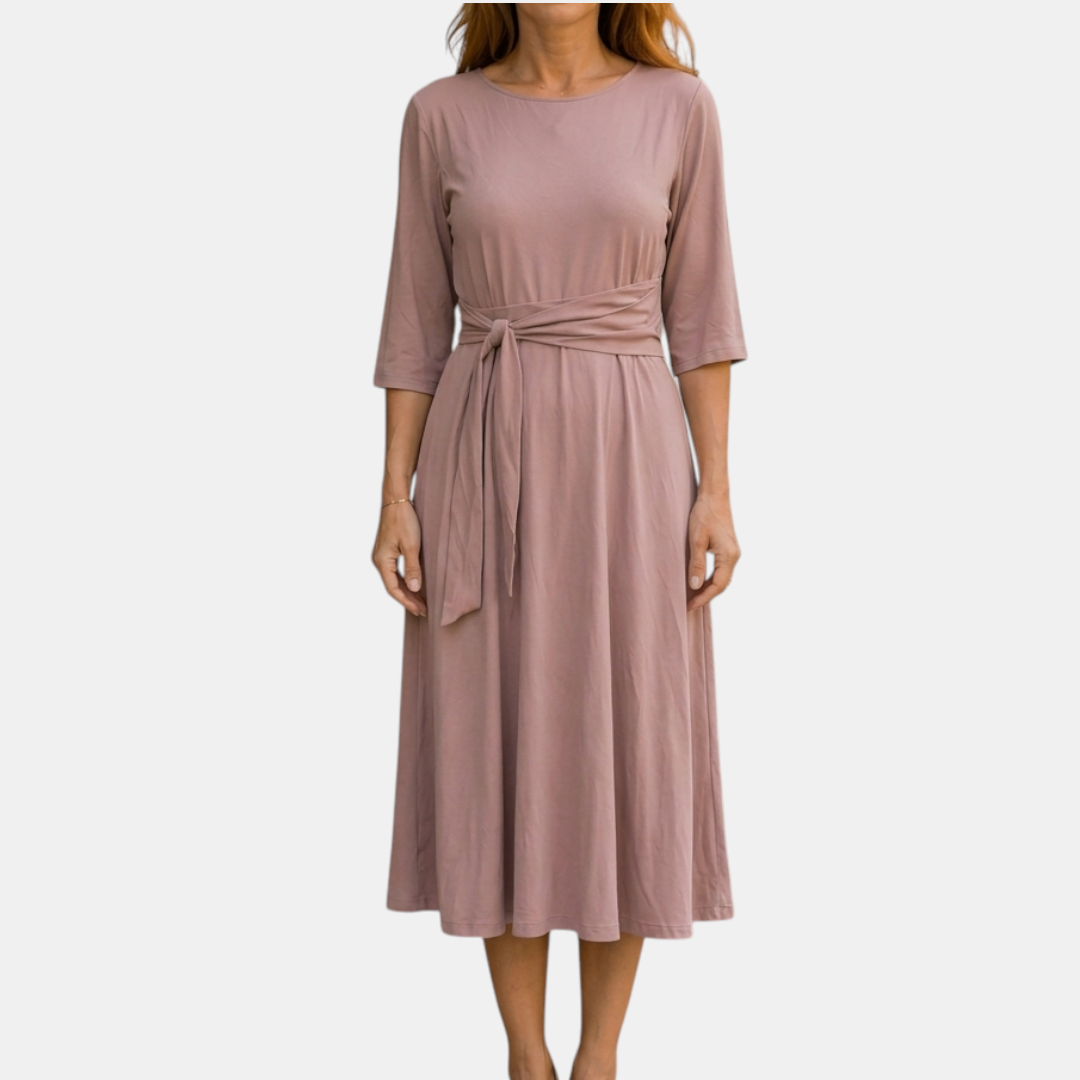 Front view of the Estelle Midi Dress Cotton A-Line Tie-Waist in pink, featuring a round neckline, three-quarter sleeves, self-tie waist belt, and a flowing A-line midi silhouette. Designed by Bella Hudson.