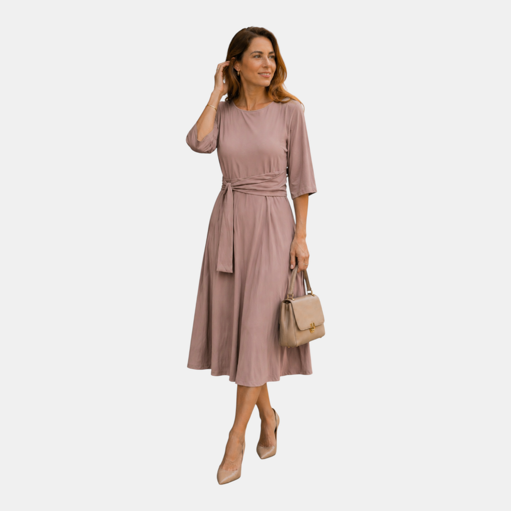 Full-body view of the Estelle Midi Dress Cotton A-Line Tie-Waist in pink, showcasing the flattering A-line silhouette, three-quarter sleeves, and elegant midi-length design. Designed by Bella Hudson.