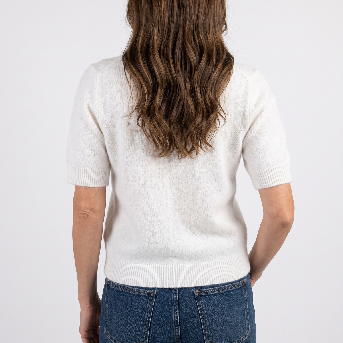 Estelle White short sleeve crewneck sweater in a close back view showing the textured knit and ribbed hem.