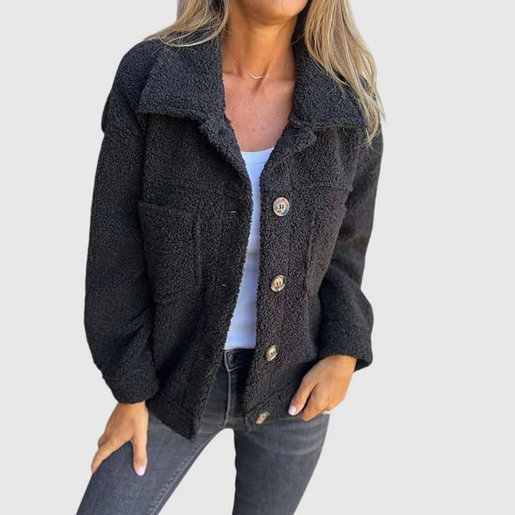 Evelyn Black teddy-fleece jacket featuring a wide lapel collar, button-front styling, chest pockets, and a relaxed silhouette