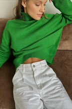 Evelyn Dark Green turtleneck sweater with white high-rise jeans, showing the ribbed hem and relaxed fit.