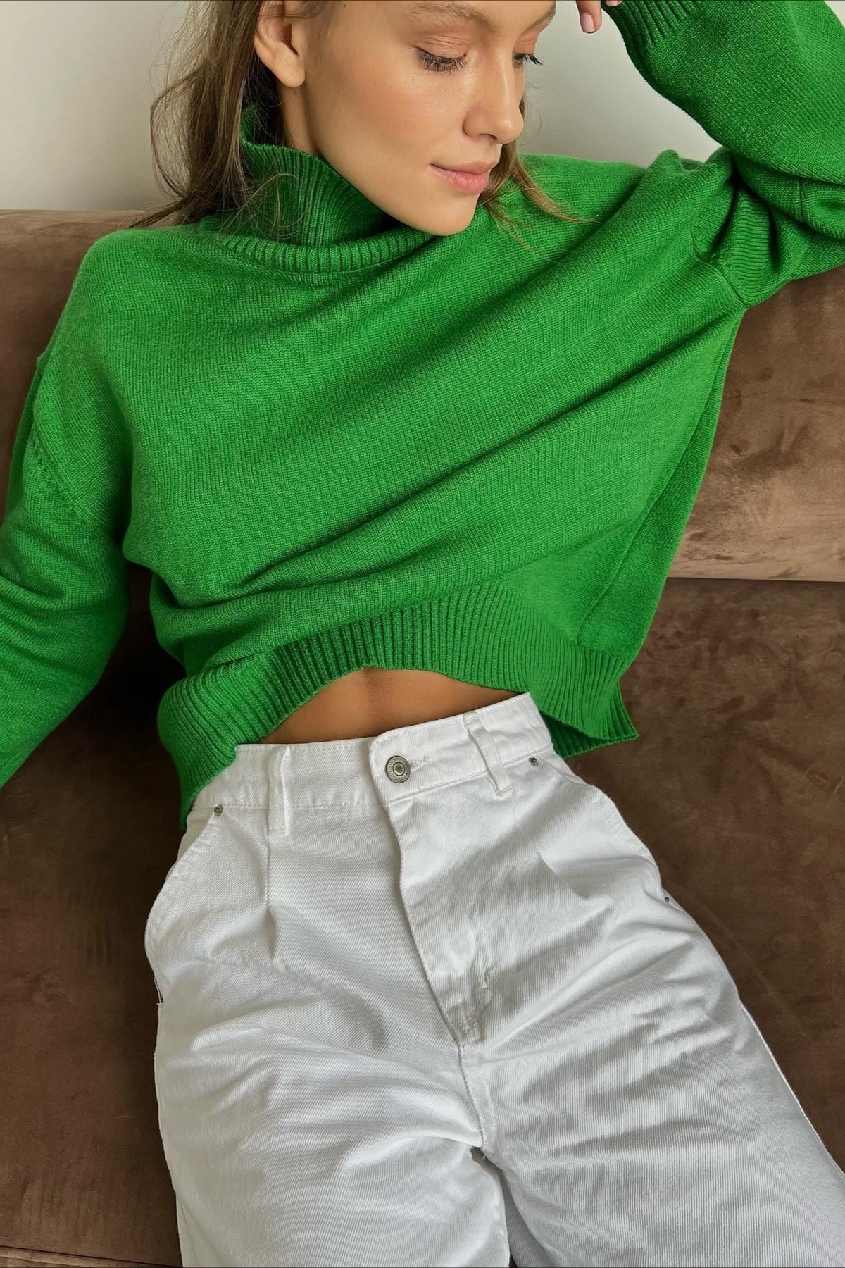 Evelyn Dark Green turtleneck sweater with white high-rise jeans, showing the ribbed hem and relaxed fit.