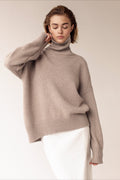 Evelyn Khaki turtleneck sweater styled with a white skirt, shown from the front with a hand at the collar.