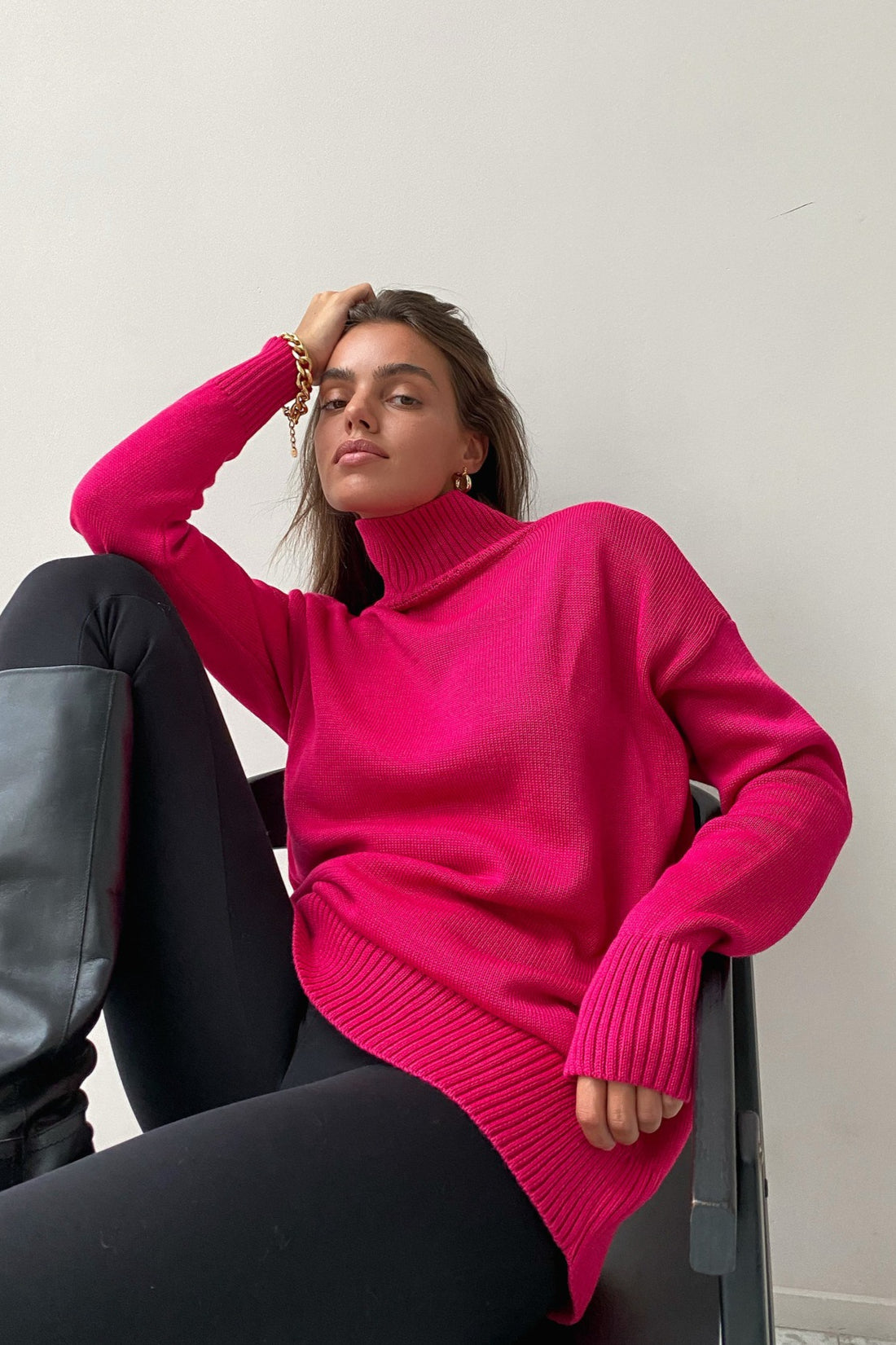 Evelyn Pink turtleneck sweater worn with black leggings and boots, showing the longer relaxed length and ribbed hem.