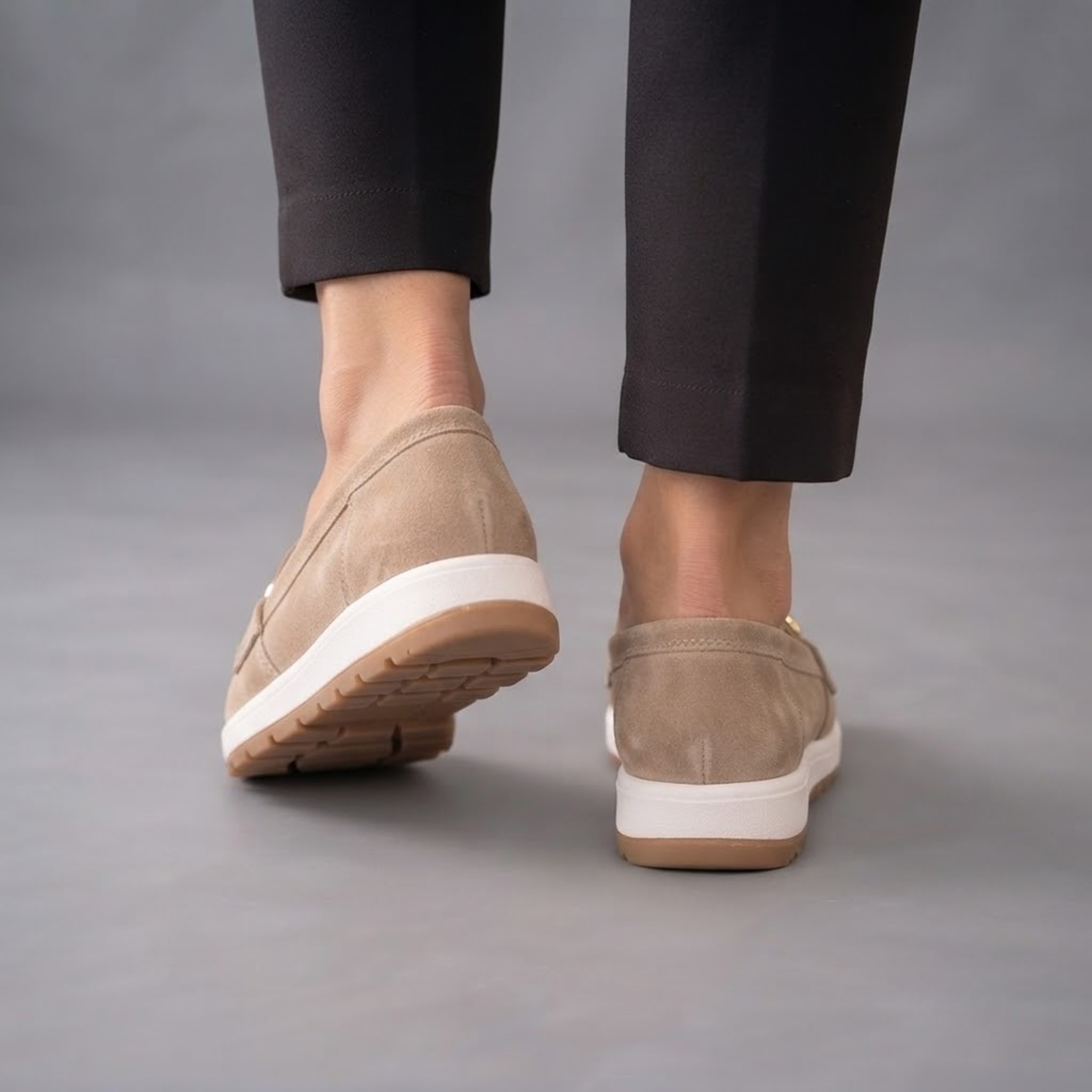 Farrah Sneaker Loafers in Beige Suede with Gold Buckle shown in back view, featuring a soft suede upper, streamlined heel, lightweight sneaker-inspired sole, cushioned footbed, durable outsole, and versatile everyday silhouette, designed by Bella Hudson.
