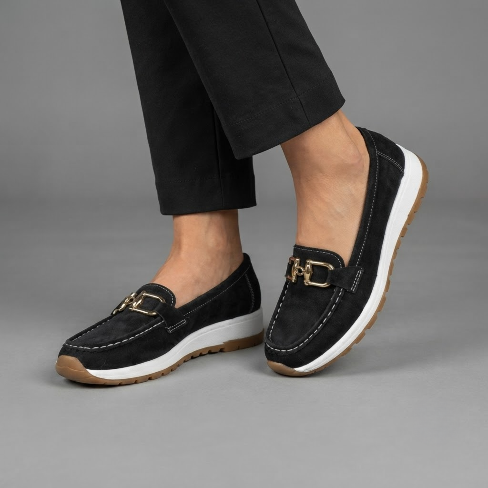 Farrah Sneaker Loafers in Black Suede with Gold Buckle shown in front view, featuring a soft suede upper, polished gold-buckle detail, slip-on loafer design, lightweight sneaker-inspired sole, cushioned footbed, and versatile everyday silhouette, designed by Bella Hudson.