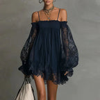 Lifestyle view of the Fenella Mini Dress Off-Shoulder Lace Puff-Sleeve Boho in navy blue, showcasing the airy babydoll silhouette, sheer lace puff sleeves, and scalloped lace hem. Designed by Bella Hudson.