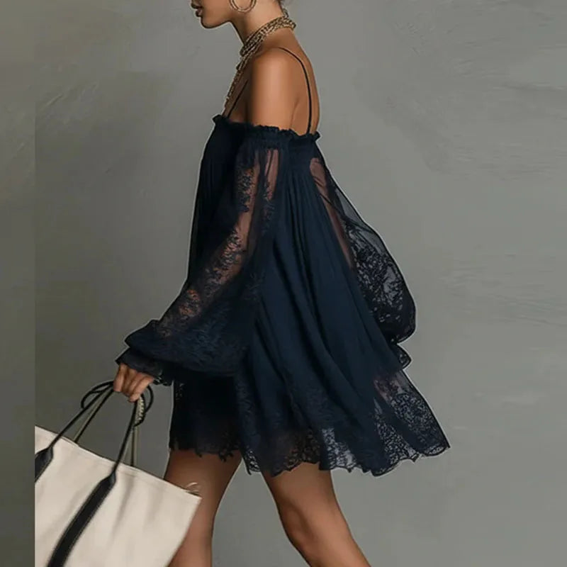 Lifestyle side view of the Fenella Mini Dress Off-Shoulder Lace Puff-Sleeve Boho in navy blue, highlighting the off-the-shoulder design, sheer lace sleeves, and flowing mixxvnvnni silhouette. Designed by Bella Hudson.