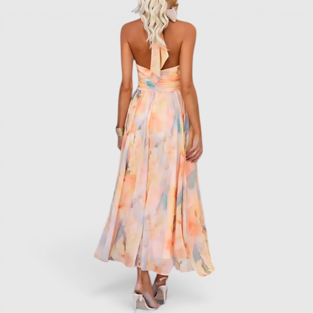 Back view of the Fenna Maxi Lightweight Dress Watercolor-Print Halter in peach, highlighting the halter-back design, cinched waist, watercolor floral print, and elegant maxi-length silhouette. Designed by Bella Hudson.