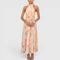 Front view of the Fenna Maxi Lightweight Dress Watercolor-Print Halter in peach, featuring a halter neckline, sleeveless design, watercolor floral print, cinched waist, and a flowing maxi silhouette. Designed by Bella Hudson.