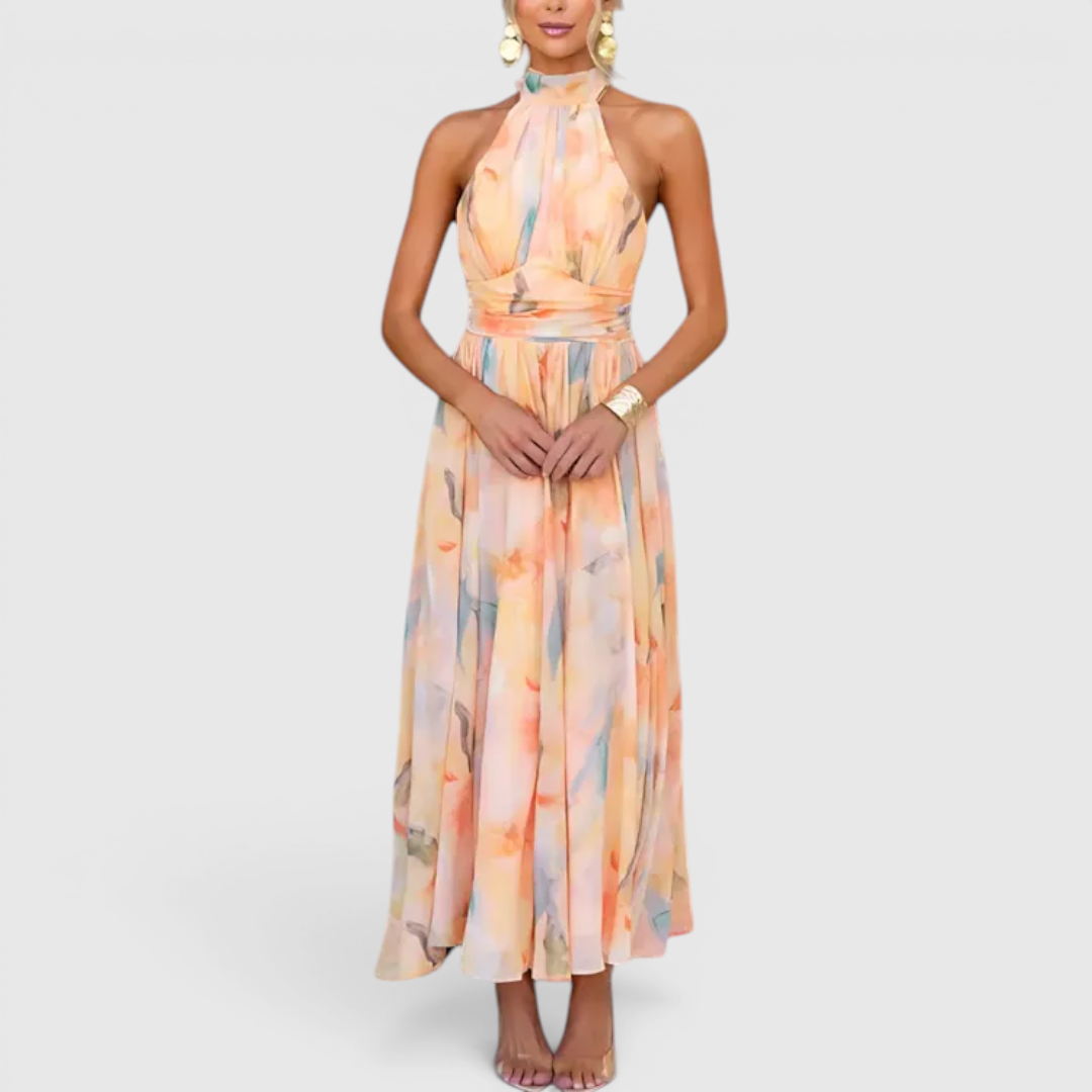 Front view of the Fenna Maxi Lightweight Dress Watercolor-Print Halter in peach, featuring a halter neckline, sleeveless design, watercolor floral print, cinched waist, and a flowing maxi silhouette. Designed by Bella Hudson.