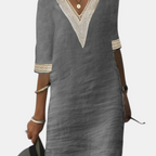 Front view of the Fenna Shift Dress Cotton Crochet-Trim V-Neck in gray, featuring a crochet-trim V-neckline, three-quarter sleeves, side pockets, and a relaxed cotton shift silhouette. Designed by Bella Hudson.
