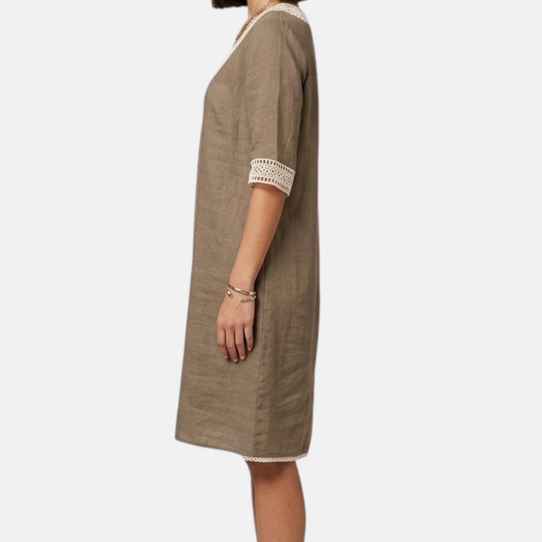 Side view of the Fenna Shift Dress Cotton Crochet-Trim V-Neck in khaki, showcasing the relaxed fit, rolled three-quarter sleeves, side pockets, and knee-length silhouette. Designed by Bella Hudson.