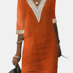 Front view of the Fenna Shift Dress Cotton Crochet-Trim V-Neck in orange, featuring a crochet-trim V-neckline, rolled sleeves, side pockets, and a comfortable knee-length shift design. Designed by Bella Hudson.