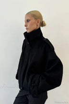 Fiona Black cropped jacket shown from the side with a tall collar and relaxed sleeve.