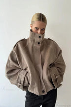 Fiona Khaki cropped stand-collar jacket shown from the front with the high collar buttoned and hands in the side pockets.
