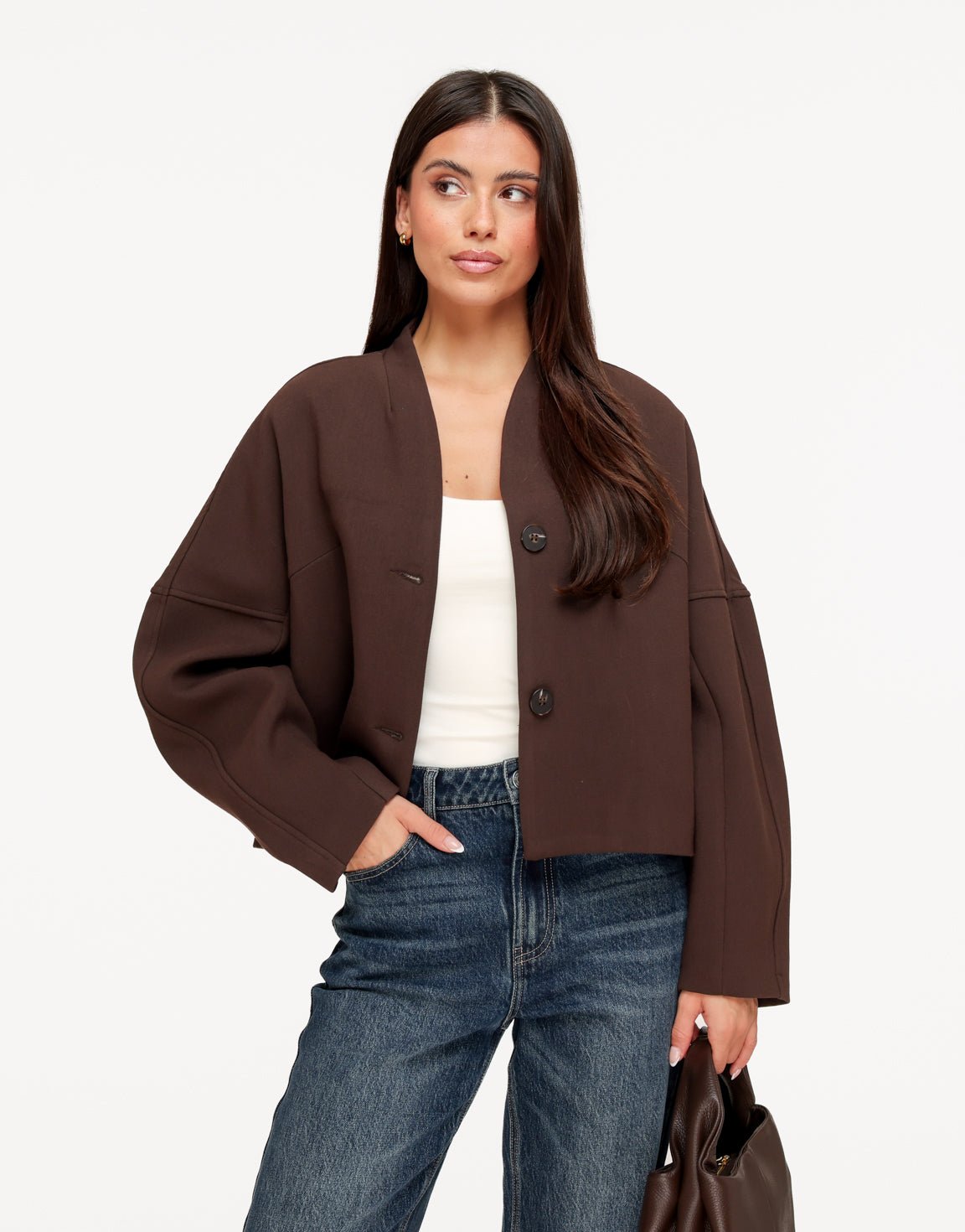Freya Brown cropped V-neck jacket worn open over a white top with jeans, showing the oversized cocoon sleeves.